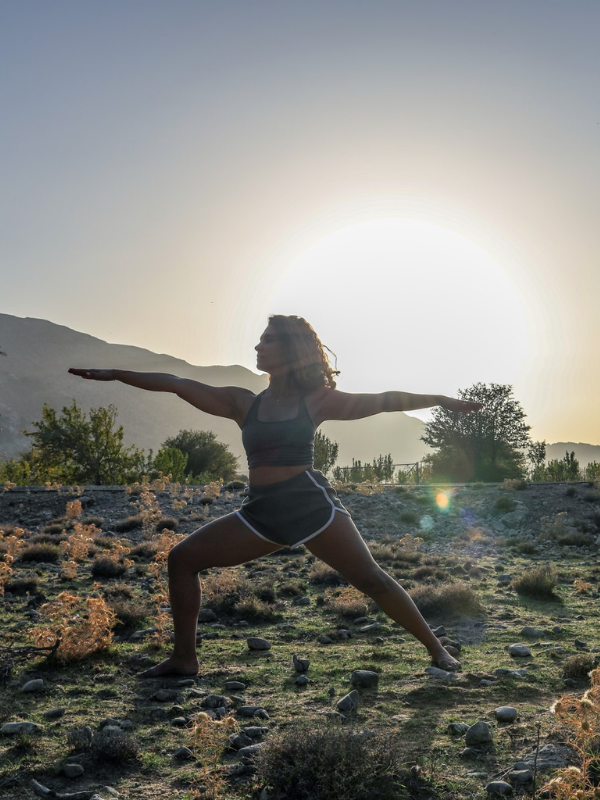 a girl doing yoga outside in the desert at sunset