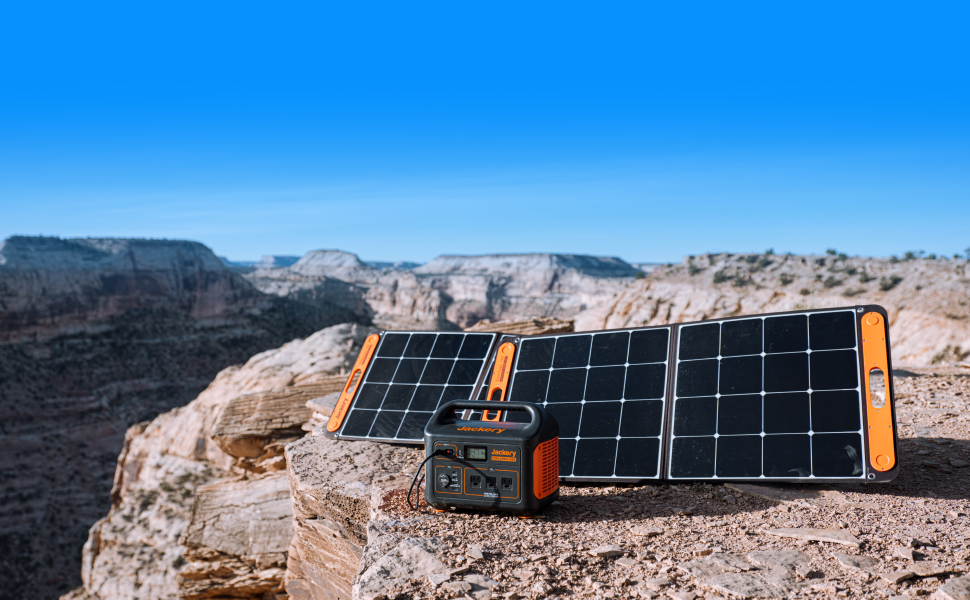 A Jackery portable power bank and solar panels on a cliff top